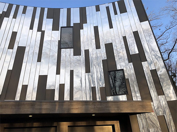 An exhibition hall with long aluminum panel cladding attached.