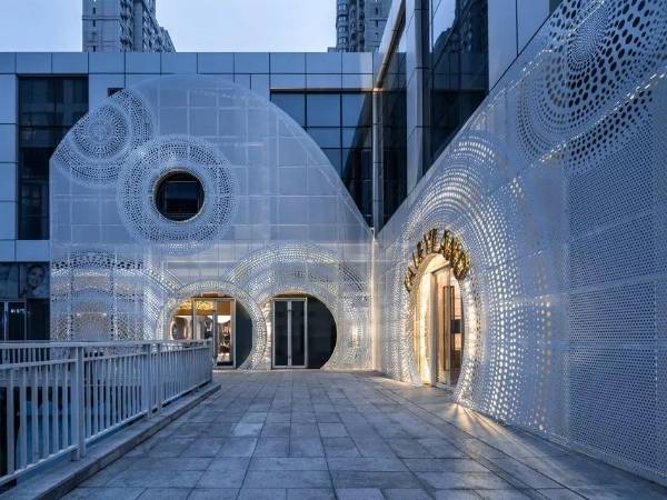 Exterior of the children restaurant building is decorated with white perforated metal sheets.