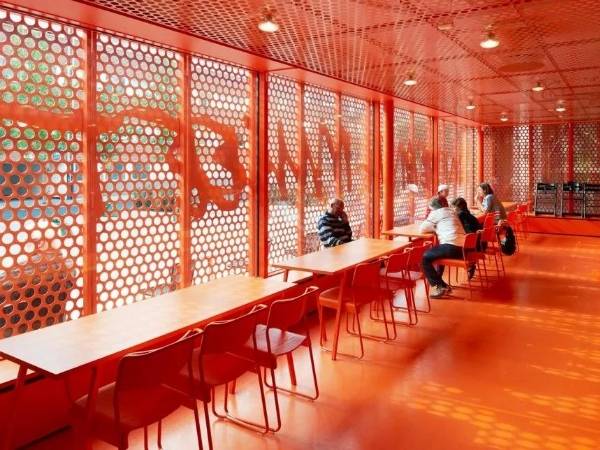 Interior of the Malmö Art Museum is decorated with red perforated metal sheets.