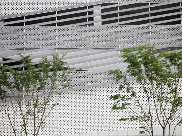 White perforated metal sheets decorate the building facade of the Nanheng pedestrian street.