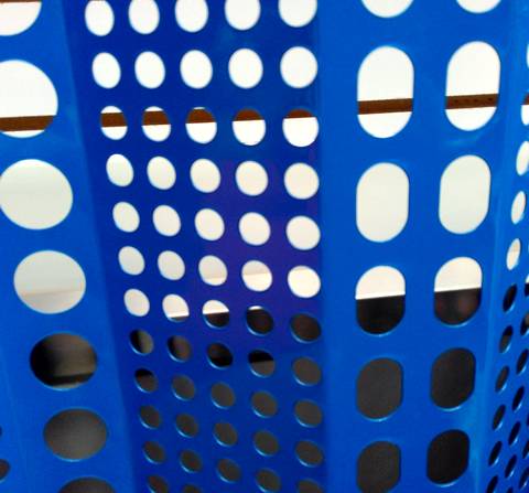 Dark blue windbreak panel with rows of round and slot holes.