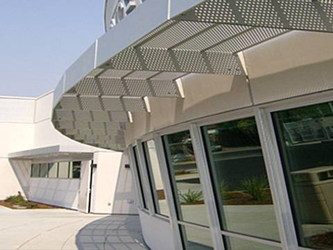 Horizontal perforated sunshade panels with round hole are fitted above the gate of public places.