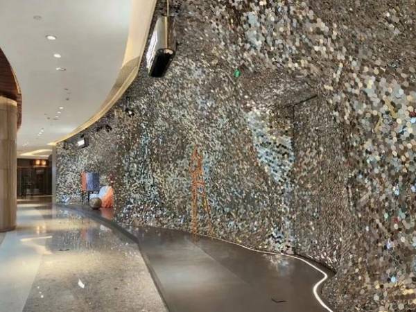 Countless perforated kinetic panels installed on on one side of the mall corridor