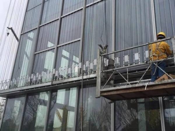 Workers set up the frames and cables on the outside of the building