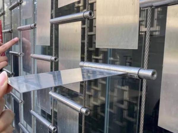 Worker is inspecting one of kinetic panels on the wall.