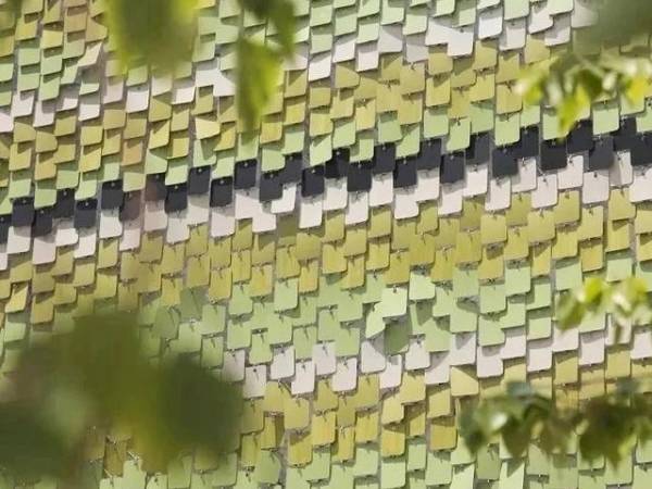 Overall effect is a green gradient on one side of a perforated kinetic facade.