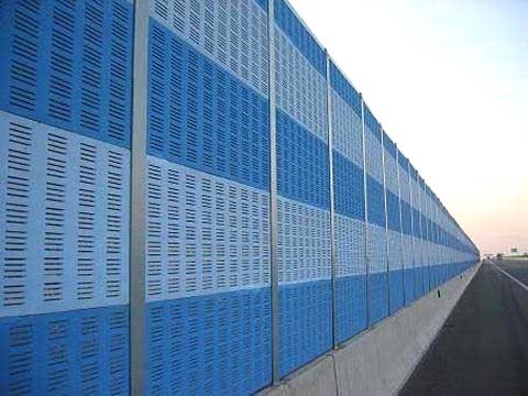 Blue and white noise barriers are installed on the highway.