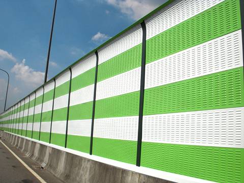 Green and white noise barriers are installed on the highway.