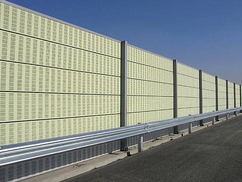 Yellow noise barriers are installed on the highway.