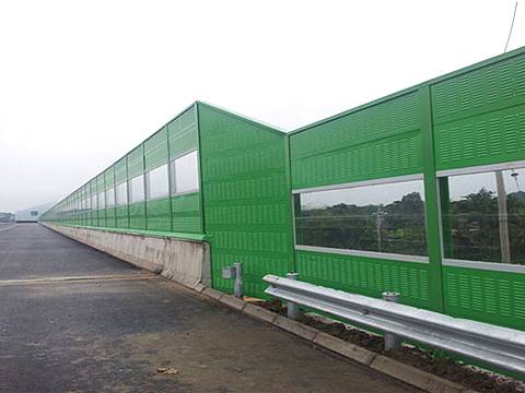 Green noise barrier with irregular shapes are installed on the highway.