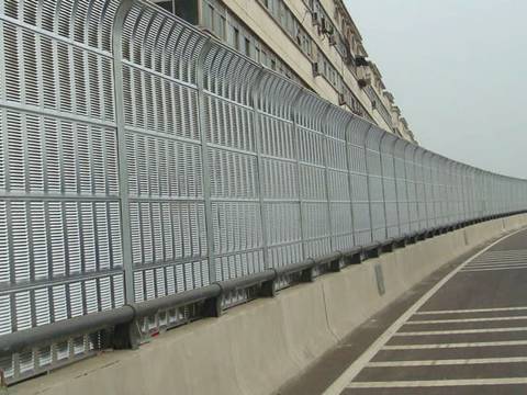 Top arc shaped noise barriers are installed on the highway.