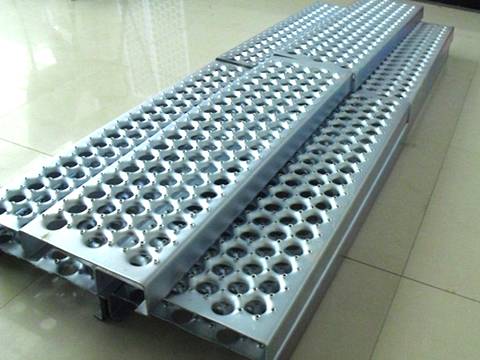 There are several anti-skid stair-treads with dented holes and galvanized surface.