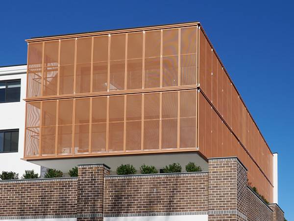 A building facade is made of perforated brass sheets