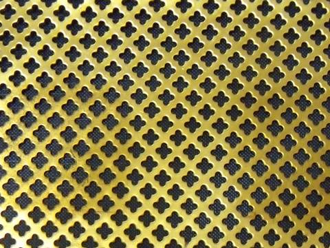 A piece of brass decorative perforated sheet with flower shape.