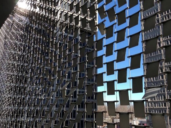 A lot of perforated kinetic facades are arranged on wall neatly.