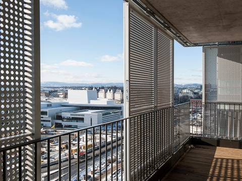 Vertical white perforated sunshade panels with round hole are fitted on balcony.