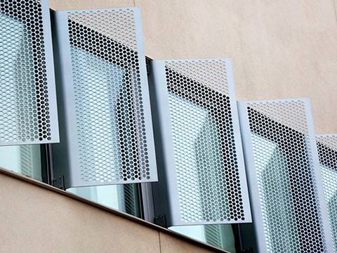 Six vertical perforated sunshade panels with hexagonal hole is installed on the windows.